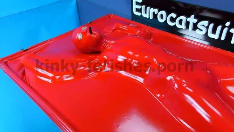 Woman in red latex vacuumbed with airtight-attached mask